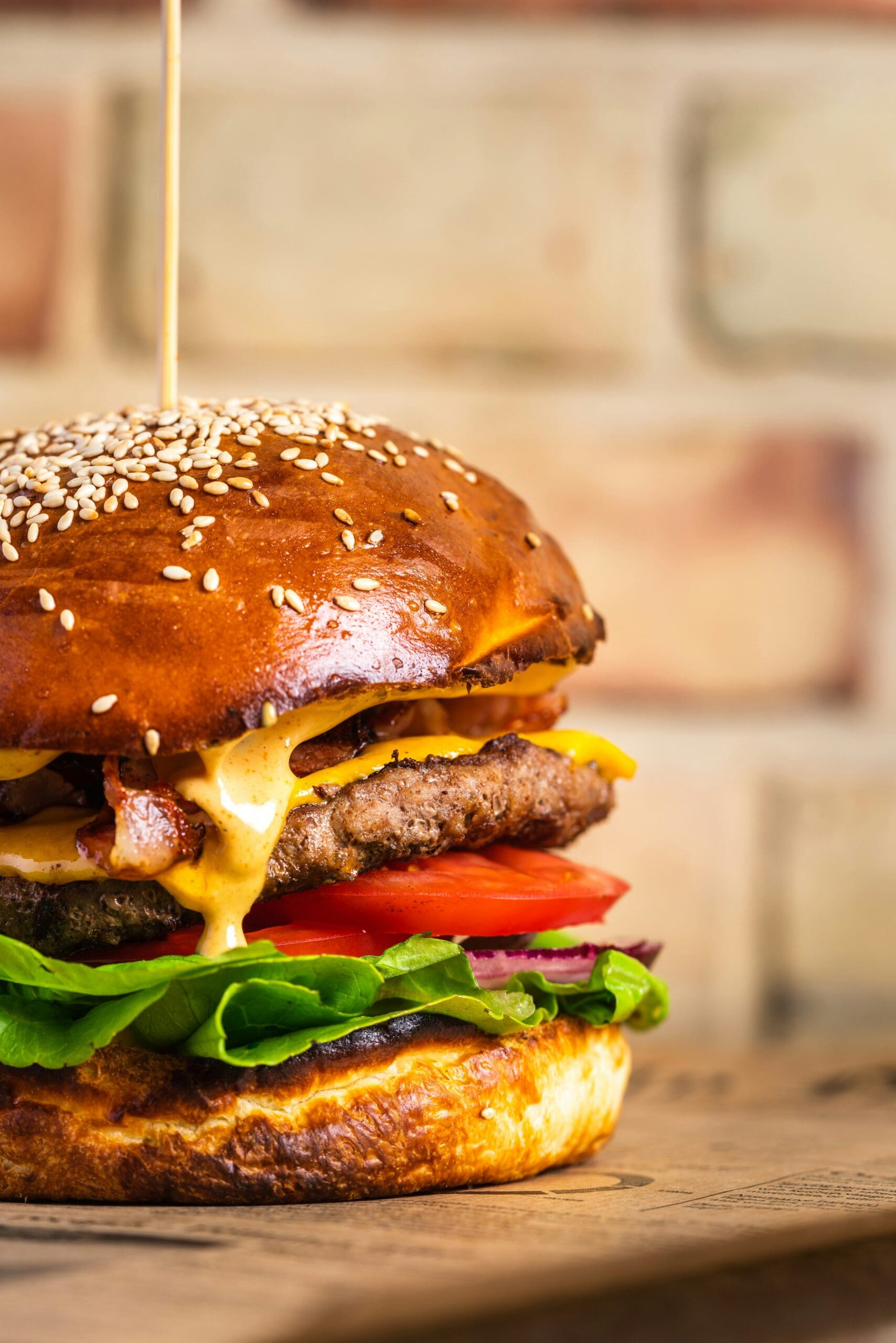 Stacked cheeseburger with melted cheese on a toasted sesame seed bun
