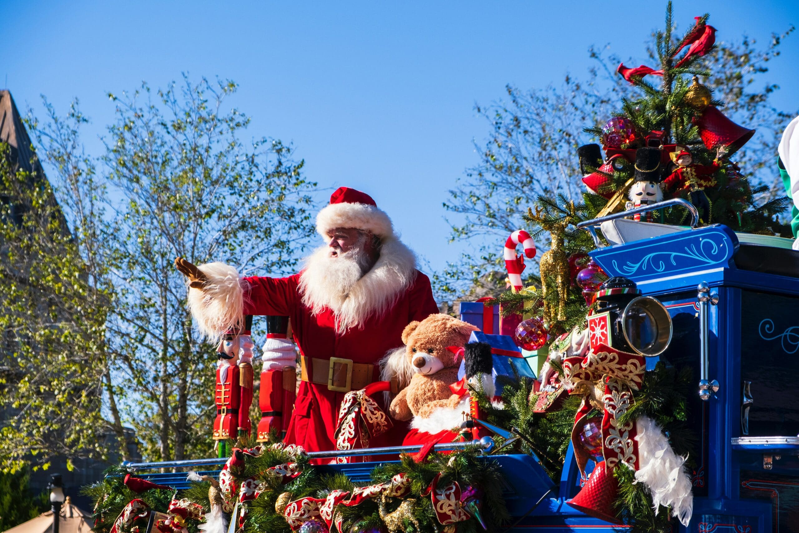 Santa Claus waving from a decorated float in a holiday parade